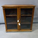 An oak glazed bookcase, with a pair of glazed doors, on turned feet, H.92 W.95 D.32cm