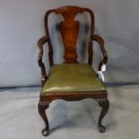 A Georgian style mahogany armchair, with shaped arms, drop-in seat, raised on floral carved cabriole