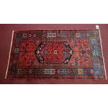 A Northwest Persian Zanjan rug, central diamond medallion with repeating petal motifs on a rouge