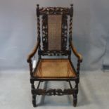 An antique Charles II style carved oak armchair, with cane back rest and seat