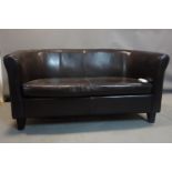 A two seater faux leather sofa, on tapered block feet, H.75 W.142 D.70cm