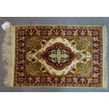 A Persian silk mat with floral medallion, on a beige ground, contained by floral border, 54 x 37cm