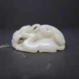 A 19th century Chinese white jade carving of a mythical beast and offspring, with pierced