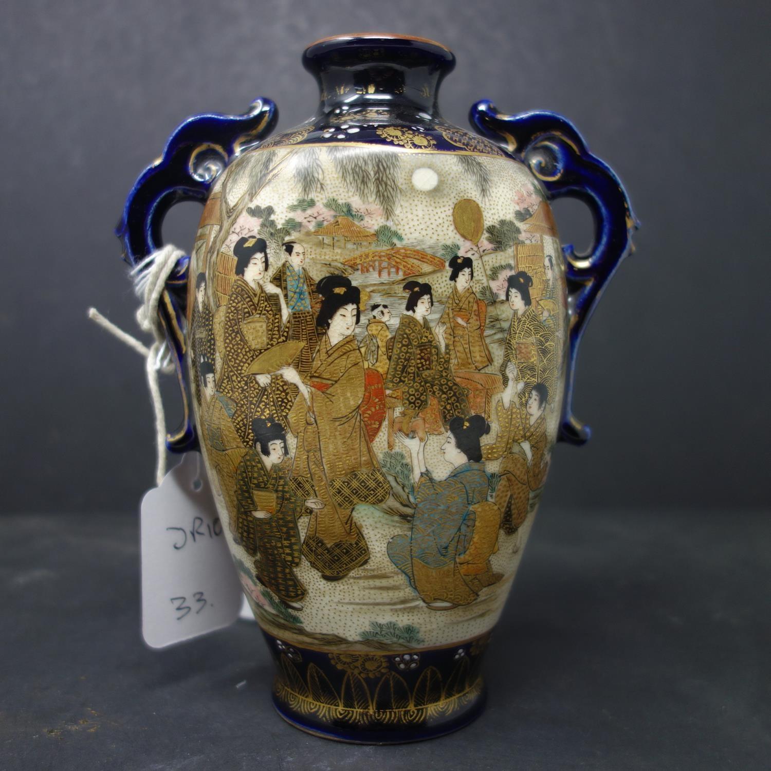 A Japanese twin handle satsuma vase, decorated with vignettes of geishas and warriors, stamped to