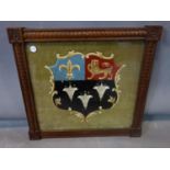 A embroidered Heraldic coat of arms, in carved frame, 35 x 38cm