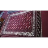 A Northeast Persian Turkoman carpet, bearing repeating Tekkeh motifs on a terracotta field,
