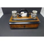 A 20th century desk stand inkwell, with two glass inkwells above single drawer, on bun feet, H.18