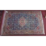 A Persian Qashqai rug, central diamond medallion and floral motifs on a dark blue ground, within