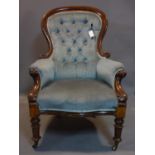 A Victorian mahogany spoon back armchair, with blue button back velour upholstery, raised on