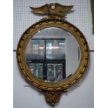 A large Regency design carved gilt circular mirror, with winged eagle surmount, having circular