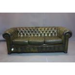 A three seater Chesterfield sofa, with green leather stud bound button back upholstery, on bun