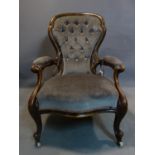 A Victorian mahogany spoon back armchair, with grey button back velour upholstery, raised on