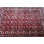 A Turkoman carpet with geometric designs on a red and black ground, 320 x 215cm