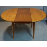 A 20th century teak oval extending dining table, with butterfly leaf, raised on tapered legs