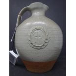 An early 1960's holy water jug in stoneware with a light green glaze and decorative cartouche of