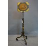 A late 19th/early 20th century ebonised and gilt painted adjustable fire guard, raised on 3 scroll