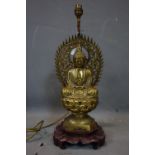 An early 20th century Chinese heavy brass statue of a seated Buddha on hardwood stand, later added