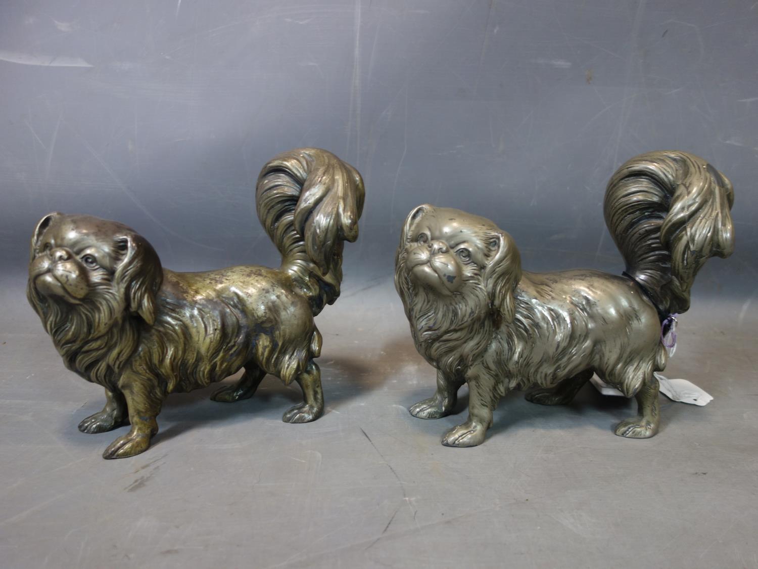 A pair of spelter Tibetan Spaniels, H.21 W.22 D.11cm