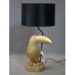 A gilt resin toucan table lamp, with black shade, H.72cm (total)