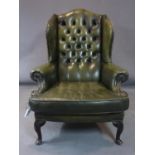 A 20th century button backed leather wingback armchair, on carved cabriole feet, H.109 W.85cm