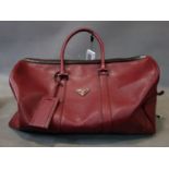 A Prada burgundy leather holdall bag