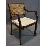 A 20th century mahogany armchair with cane back rest