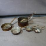 A set of 5 old graduating brass saucepans and another larger D.27cm