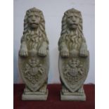 Two reconstituted stone lions holding armorial shields, H.78cm (2)