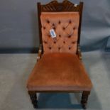 An Edwardian mahogany nursing chair with button back velour upholstery