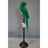 A green fibre glass model of a parrot on stand, H.90cm