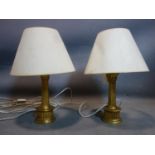 A pair of gilt porcelain table lamps with shades