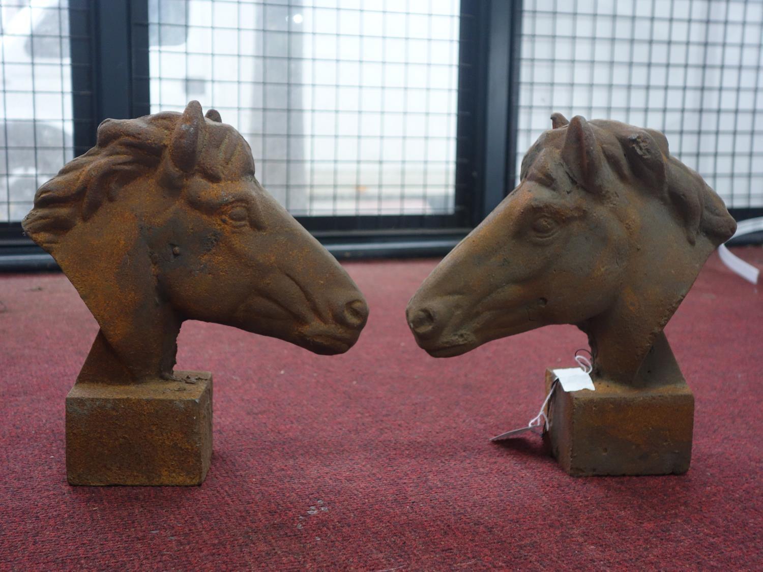 Two cast iron horse heads on block bases, H.30cm