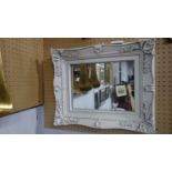 A wall mirror with white painted floral frame, having rectangular glass plate, 50 x 60cm