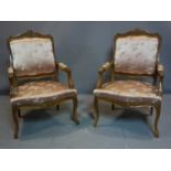 A pair of French Louis XV style oak armchairs with silk upholstery