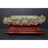 A 20th century Chinese jade tablet of 2 mythical beasts, 5 x 22cm, with fitted hardwood stand