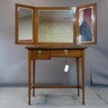 An early 20th century mahogany dressing table with folding triptych mirror over 2 drawers, raised on