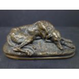 A bronze figure of a sleeping dog on a naturalistic base, H.6 W.15 D.7cm