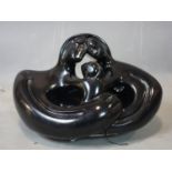 A black plaster sculpture of a family embracing, signed and dated 1973 to base, artists proof, H.