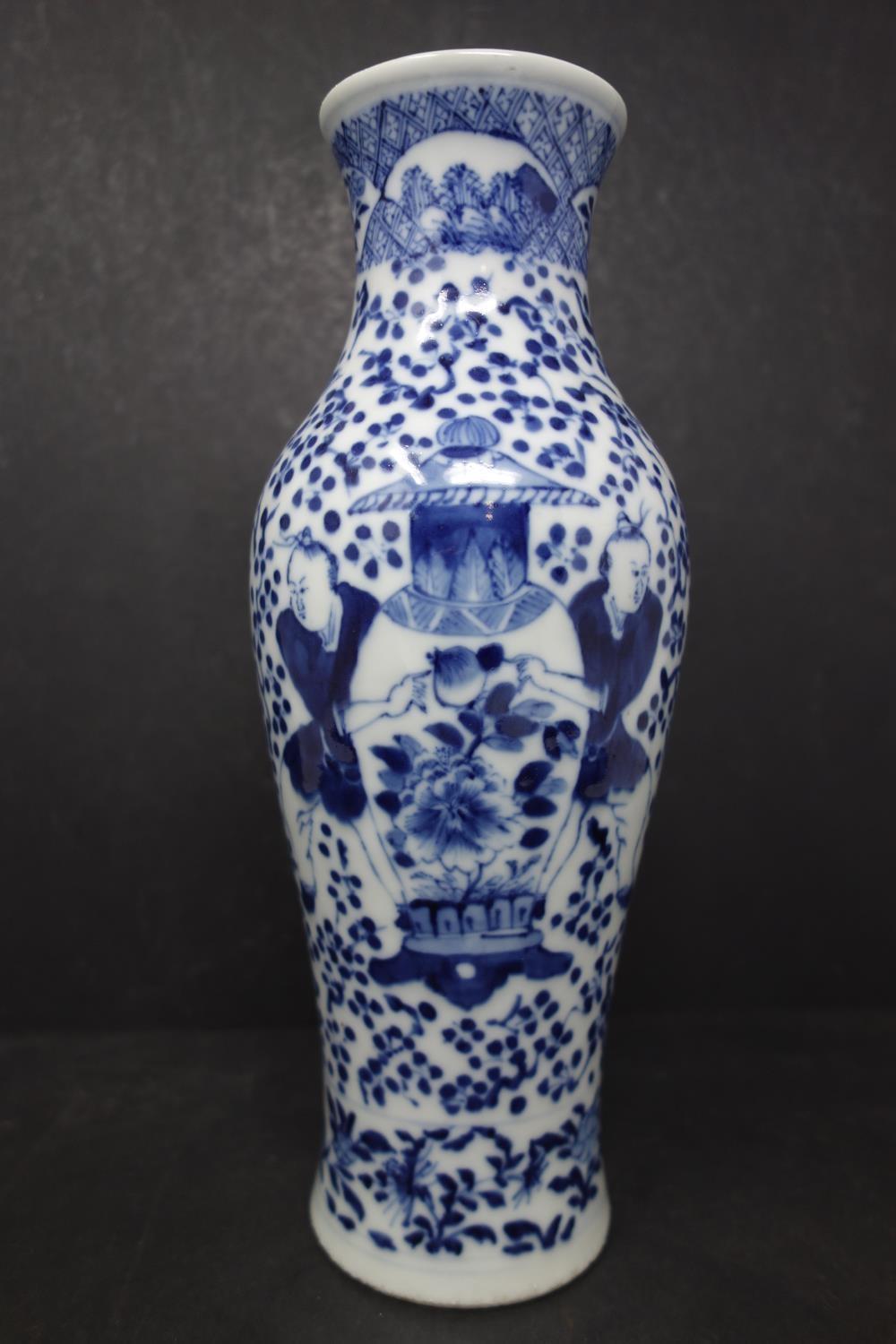 A late 19th century Chinese blue and white porcelain vase, decorated with 2 figures holding a vase