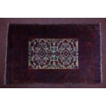 A Persian rug with central geometric design, on a beige ground, contained by geometric red and