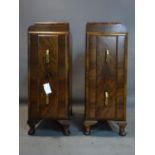 A pair of Art Deco walnut pedestal chests of two drawers, having Bakelite handles, raised on squat