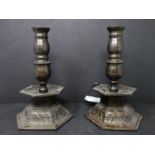 A pair of early 20th century bronze candlesticks, with knopped stems raised on hexagonal floral