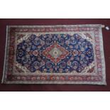 A Northwest Persian Sarouk rug, central floral medallion with repeating petal motifs on a sapphire
