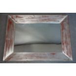 A rectangular wall mirror with red and silver distressed painted frame, 103 x 77cm