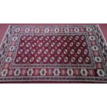 A Northeast Turkoman carpet, repeating stylised all over Tekkeh motifs on a rouge field,