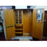 A 1930's limed oak 'Compactum' wardrobe in two parts, one with two cupboard doors and the other with
