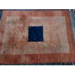 A large Persian Gabbeh carpet, with blue central square on an orange ground, 289 x 210cm