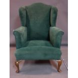 A 20th century Georgian style blue velour upholstered wing back armchair, H.116 W.84 D.80cm