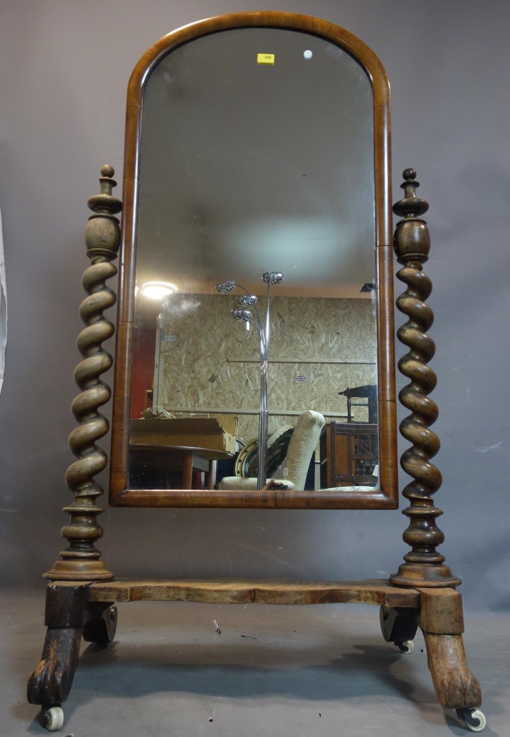 A Victorian mahogany cheval mirror, with barley twist supports, raised on scroll feet and castors,