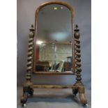 A Victorian mahogany cheval mirror, with barley twist supports, raised on scroll feet and castors,